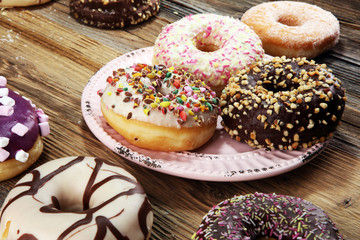 assorted donuts with chocolate frosted, pink glazed and sprinkles donuts