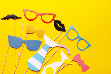 Photo booth props glasses, mustache, lips on a pink background flat lay. Birthday parties and...