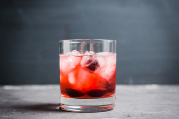 Old fashioned cocktail with cherry. Selective focus.