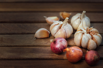 Garlic and onion on wooden background have cloves top