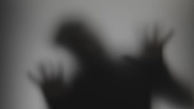 Shadowy figure behind glass / fear, panic concept