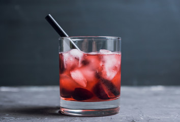 Old fashioned cocktail with cherry. Selective focus.