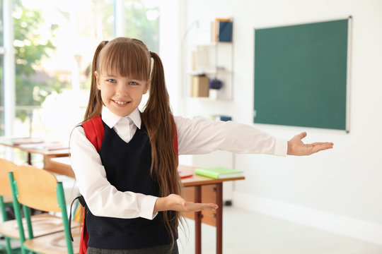 Little girl in classroom. Stylish school uniform