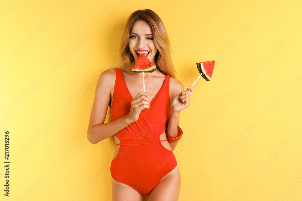 Wall mural pretty young woman with juicy watermelon on color background