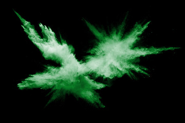 Green powder explosion on black background.