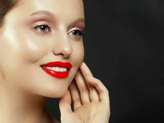 Fototapeta premium Makeup, cosmetics. Beauty young woman portrait. Beautiful model girl with beauty makeup, red lips, perfect fresh skin. Attractive lady with green eyes. Youth and Skin Care Concept