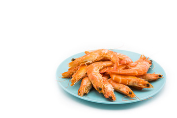 Grilled shrimps on blue plate isolated on white background. Copyspace
