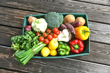 Variety or mixed a lot kind of vegetable in the paper green box on wooden floor