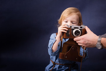 Child explore a vintage photo camera and father helps her © lenaivanova2311