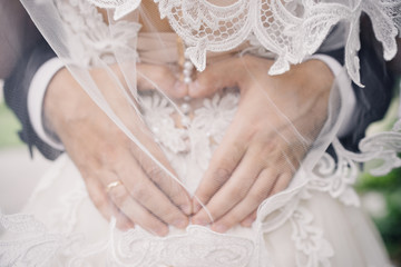 wedding photo of wedding rings on the groom's hands. heart