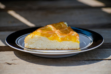 Delicious cake with apricot jam on a plate. Crostata with marmalade or peach jam filling. Homemadepie dessert with dandelion jam.