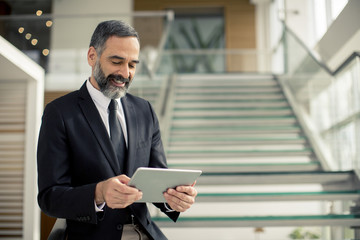 Handsome senior businessman with digital tablet in the modren office