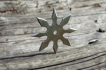 Shuriken (throwing star), traditional japanese ninja cold weapon stuck in wooden background