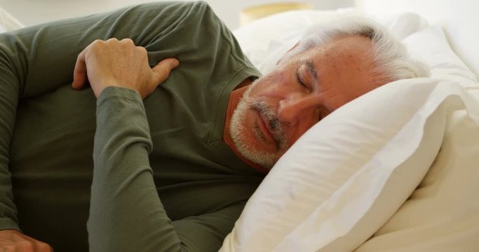 Senior man sleeping on bed in bedroom 4k