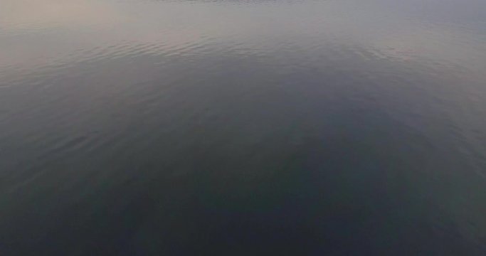 4K Drone footage of bridge beetween two island low to the water. Tilt up on bridge with beautiful colours. Teel and orange.
