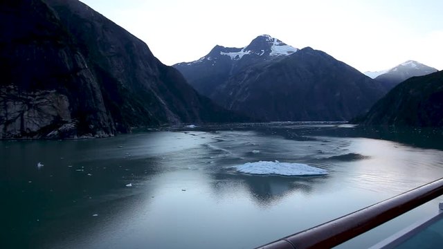 Striking mountains and a large iceberg are seen in Tracy Arm Fjord near Juneau, Alaska. Untamed, natural wilderness and wildlife with incredible landscape. Slow motion.