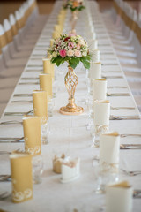 Wedding table with exclusive floral arrangement prepared for reception, wedding or event centerpiece in romantic gold style