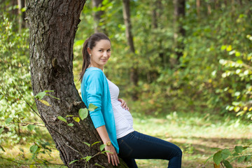 Beautiful pregnant woman in the forest