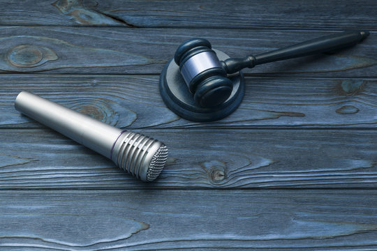 microphone, hammer of a judge on a wooden background. copyright infringement. music, songs