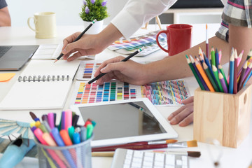 Team of creative designers working with tablet for new project in a design studio