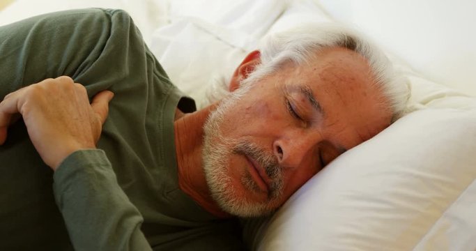 Senior man sleeping on bed in bedroom at home 4k