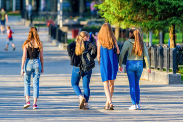 four girlfriends are walking in the park