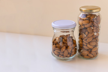 Almonds freshly caught in two cans with white background.