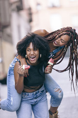 beautiful ethnic black girlfriends smiling and eating ice cream