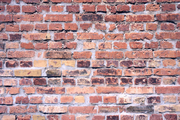 Red brick wall background. Old brickwork with untidy joints, partly damaged. Texture block side for background. Old crooked brick wall. Orange block side. Old grunge brick wall background