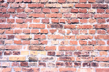 Red brick wall background. Old brickwork with untidy joints, partly damaged. Texture block side for background. Old crooked brick wall. Orange block side. Old grunge brick wall background