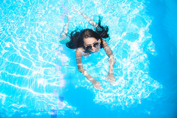 Beautiful girl is swimming in the pool