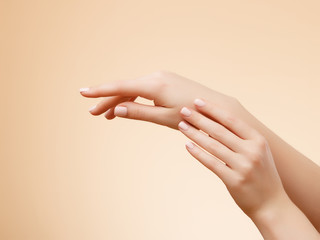 Closeup image of beautiful woman's hands with light pink manicure on the nails. Skin care for hands, manicure and beauty treatment. Elegant and graceful hands with slender graceful fingers