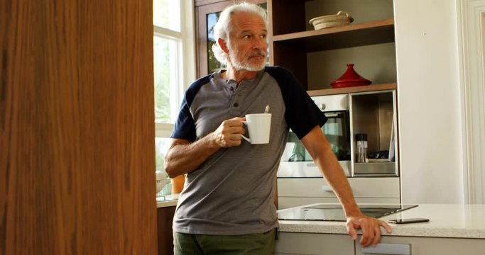 Senior man having coffee in kitchen at home 4k