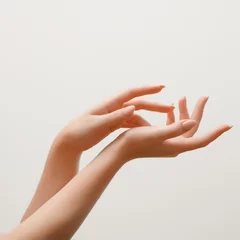 Fototapeten Nahaufnahmebild der Hände der schönen Frau mit hellrosa Maniküre auf den Nägeln. Hautpflege für Hände, Maniküre und Schönheitsbehandlung. Elegante und anmutige Hände mit schlanken, anmutigen Fingern © looking2thesky
