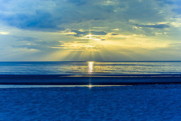 Landscape sunset on the beach with light flare on the ocean in cross process color.