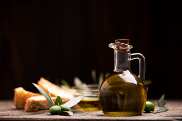 Obraz na płótnie Canvas Olive oil with bread on a wooden table.