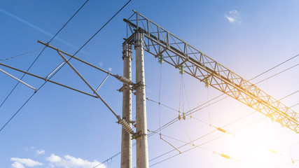 Power lines on the railway. Blue sky, sunlight. Railway