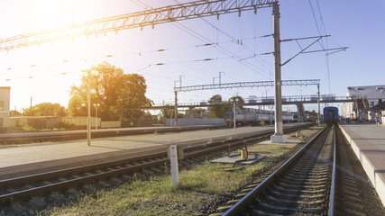Power lines on the railway. Blue sky, sunlight. Railway