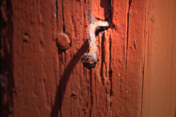 Bend nail in an old red wooden door