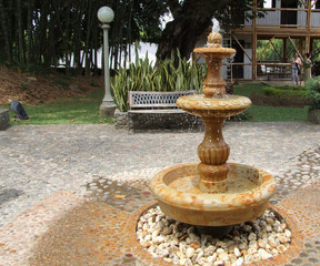 fuente de agua en piedra en mitad de un parque 