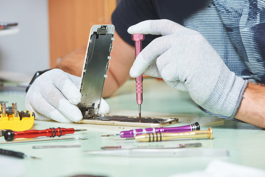 Smart Phone Repair. Repairman Hands With Screwdriver