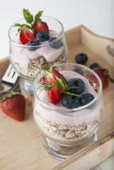Healthy breakfast for two, oat meal with fruits: blueberry, strawberry and min, parfait in in two glasses on a rustic background. Healthy food. Isolated.