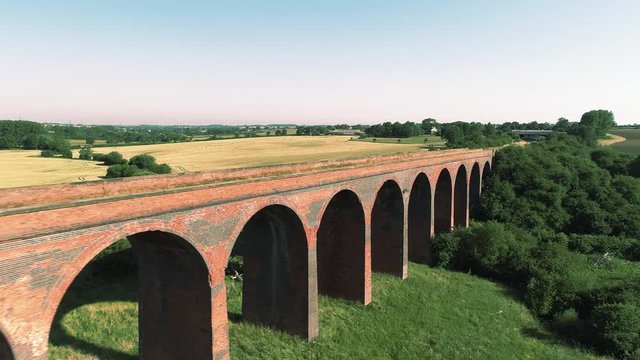 Aerial close up and reveal of a disused railway viaduct in Leicestershire, England.