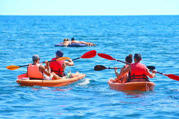 A group of kayaks are swimming by the sea. Kayaking background...