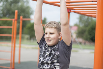 Fototapeta premium a boy with blond hair is engaged in the Playground