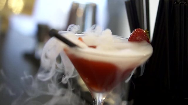 Beautiful strawberry cocktail with real fruit. The best part is the dry ice added to the drink to make a fake smoke effect. there is a lot of smoke coming out of the drink.
