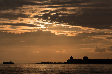 Fototapeta na wymiar Turkey, Aegean sea and ferry services in Izmir bay with orange cloud beautiful sunset.