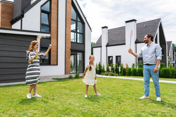 My turn. Nice young woman holding a shuttlecock while playing badminton with her husband
