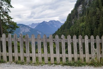 Fokus auf alten Holzzaun vor Bergpanorama