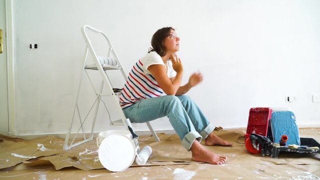 Painting Equipment in the room and discouraged women having problems with renovations